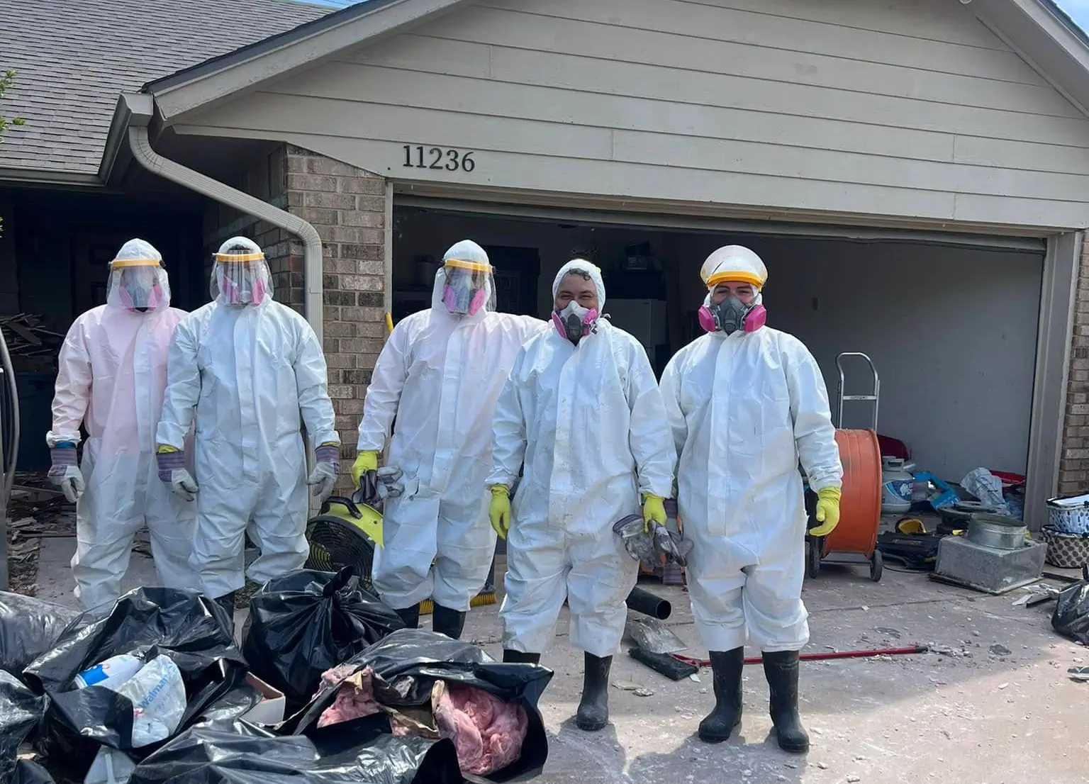 A group of workers lined up in front of a house after a restoration job.