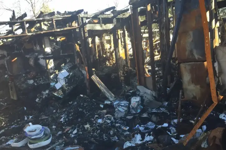 Burned office interior showing fire and smoke damage across work areas