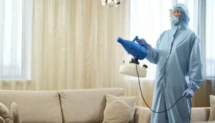 Worker removing odor from a living room. Worker removing odor from a living room.