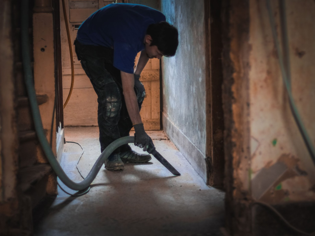 A professional crew using a heavy-duty vacuum for water mitigation cleanup.
