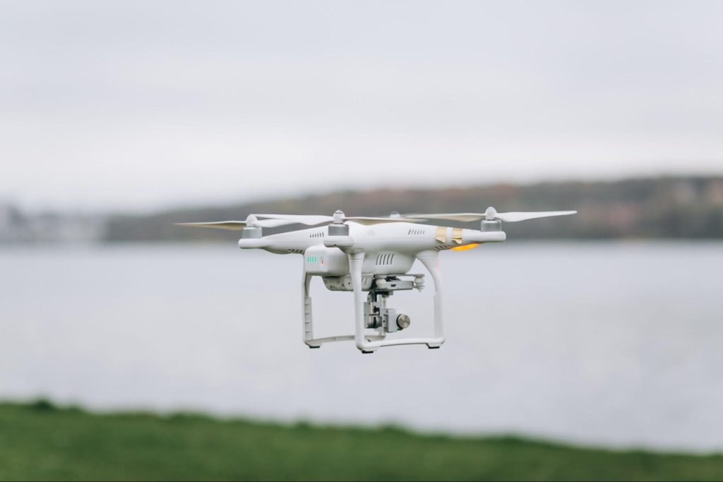 A white drone flies overhead, capturing aerial photos and video.