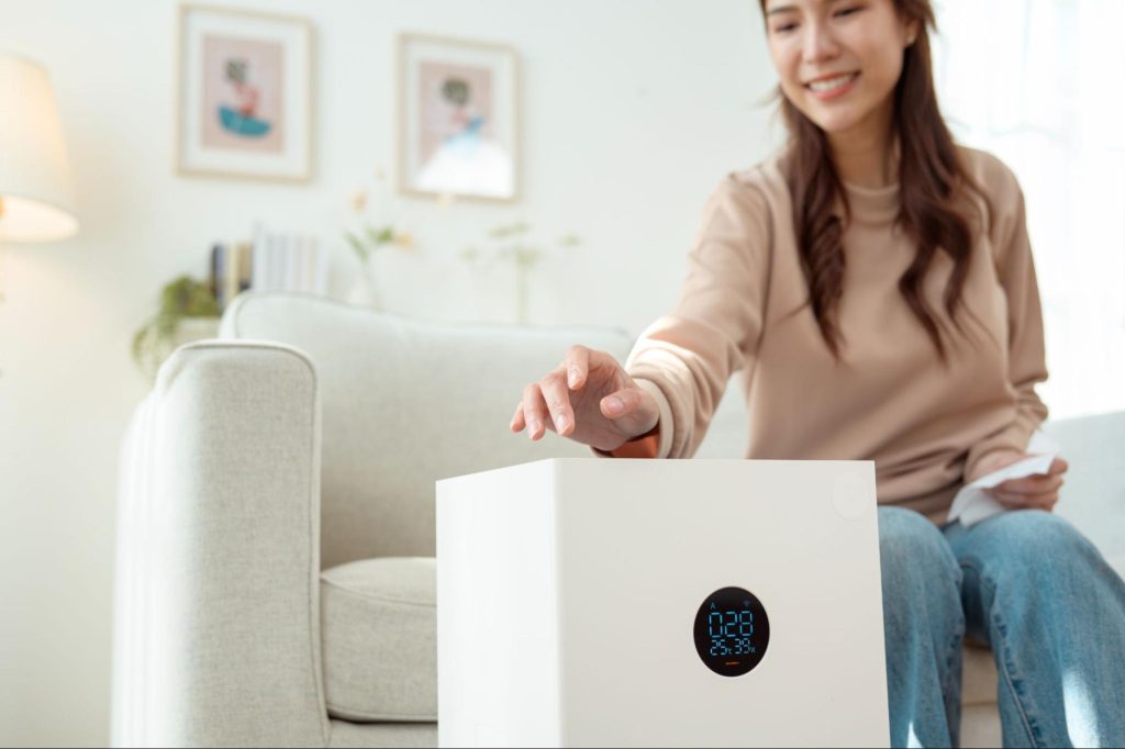 A woman using an air purification system.