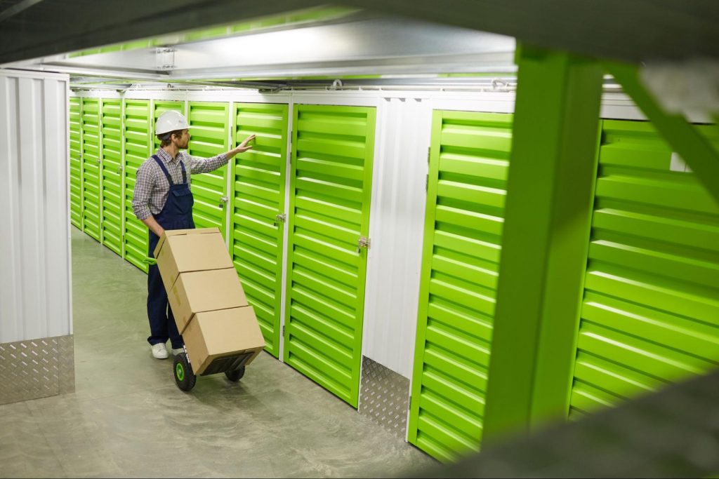 A man loading boxes on a dolly into a temperature controlled storage unit.