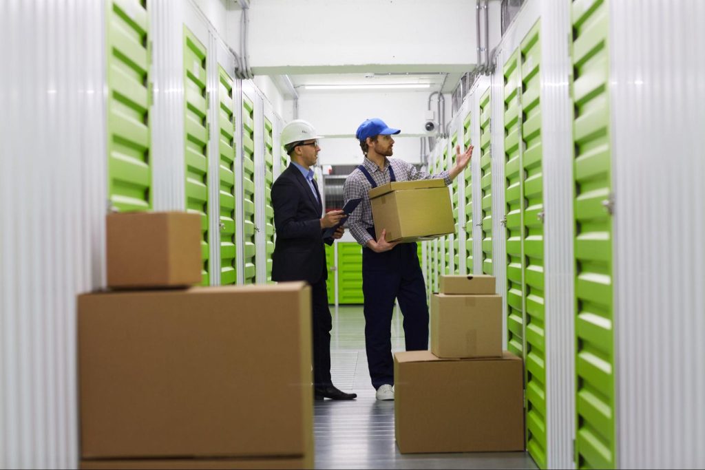 Two people unloading boxes into temperature controlled storage.